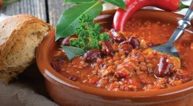 bowl of chili with garnish and crusty bread