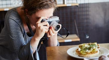 woman taking photo of food