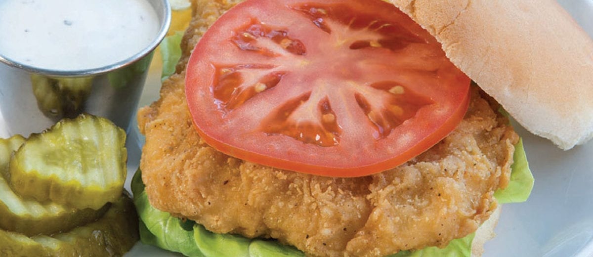 fried chicken on a bun with lettuce and tomato