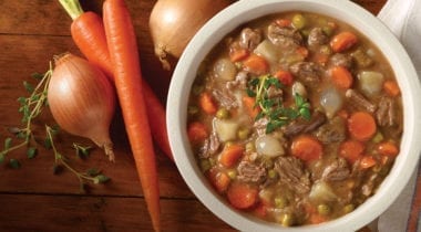 beef stew in a bowl with carrots and onion