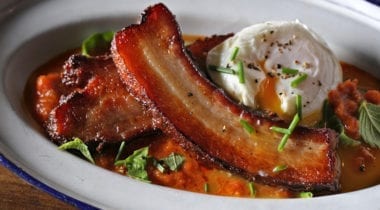 fried pork belly in a dish with soft cooked egg