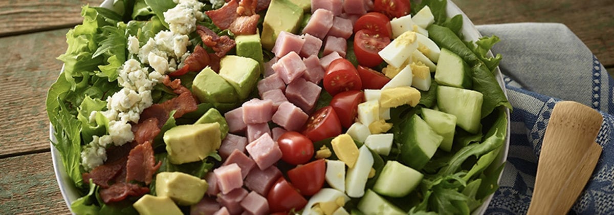 salad with diced cucumbers, egg, tomato, ham, avocado, bacon and bleu cheese