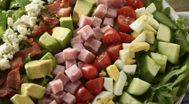 salad with diced cucumbers, egg, tomato, ham, avocado, bacon and bleu cheese