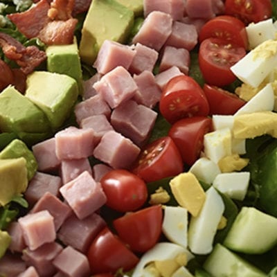 salad with diced cucumbers, egg, tomato, ham, avocado, bacon and bleu cheese