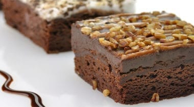 brownies with chocolate fudge topping and crushed walnut topping