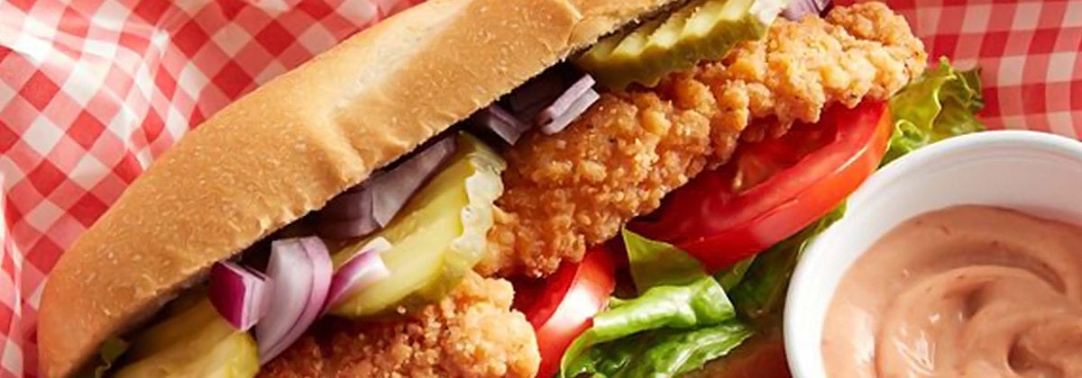 chicken sandwich with tomato, onions and pickles