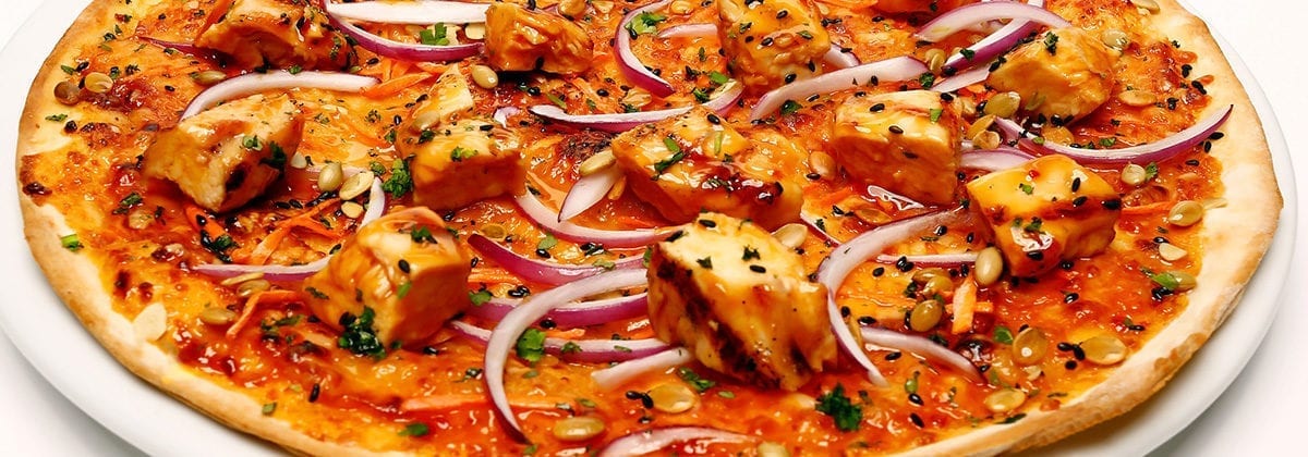 thai chicken with red onions on pizza