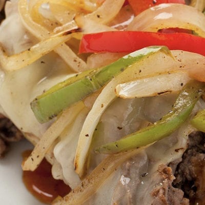 steak topped with peppers and onions