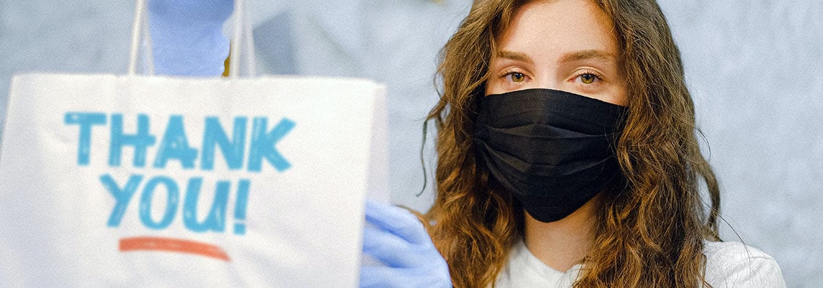 woman in mask holding takeout bag