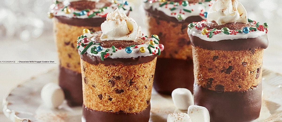 chocolate chip cookies shaped like shot glasses filled with chocolate and whip cream