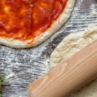 pizza dough, sauce on dough, rolling pin
