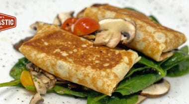 stuffed crepes on spinach with mushrooms
