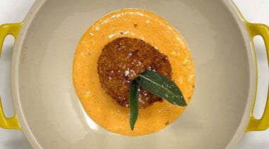 fried breaded food ball on orange sauce