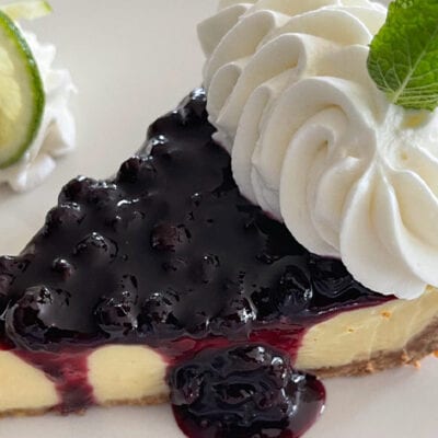 lemon lime pie slice with blueberry sauce and whip cream