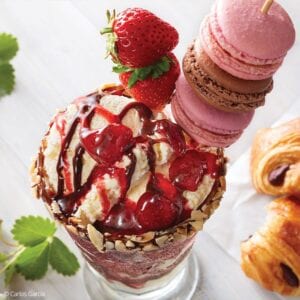 Parisian ice cream sundae topped with strawberries and macarons.