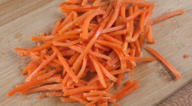 Matchstick-shaped carrots on cutting board