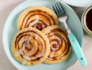 Cinnamon roll pancakes on blue plate