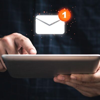 hand with an ipad and floating email icon