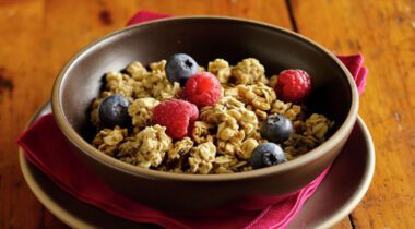 bowl of granola cereal with blueberries and raspberries