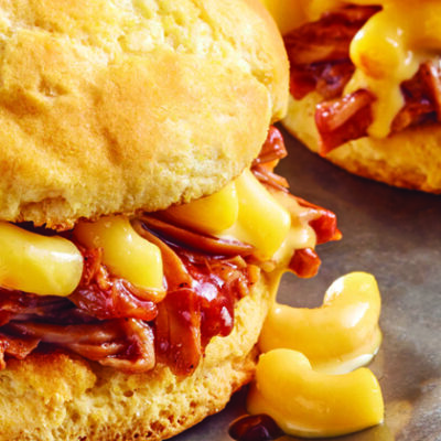 two pulled pork Mac n' cheese sandwiches on biscuits, plated on metal plate
