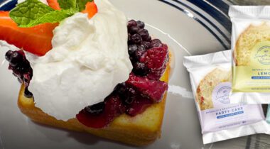 whipped cream, mixed berries, atop a lemon cake. On blue and white plate. three single serve simple joy cakes packaged.