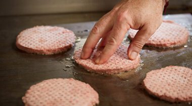 putting burger patties on a griddle