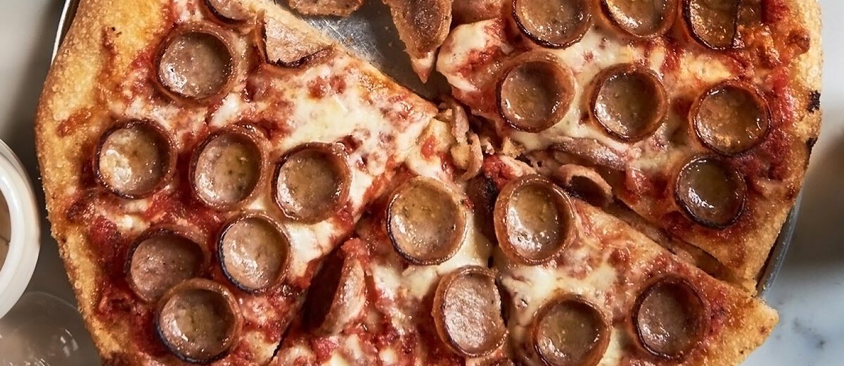 cooked cupped sausage slices on a pizza