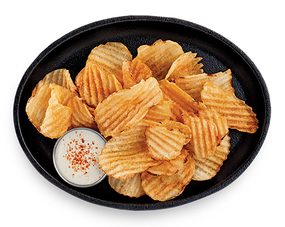 fresh fried crinkle chips on black oval plate with dipping sauce