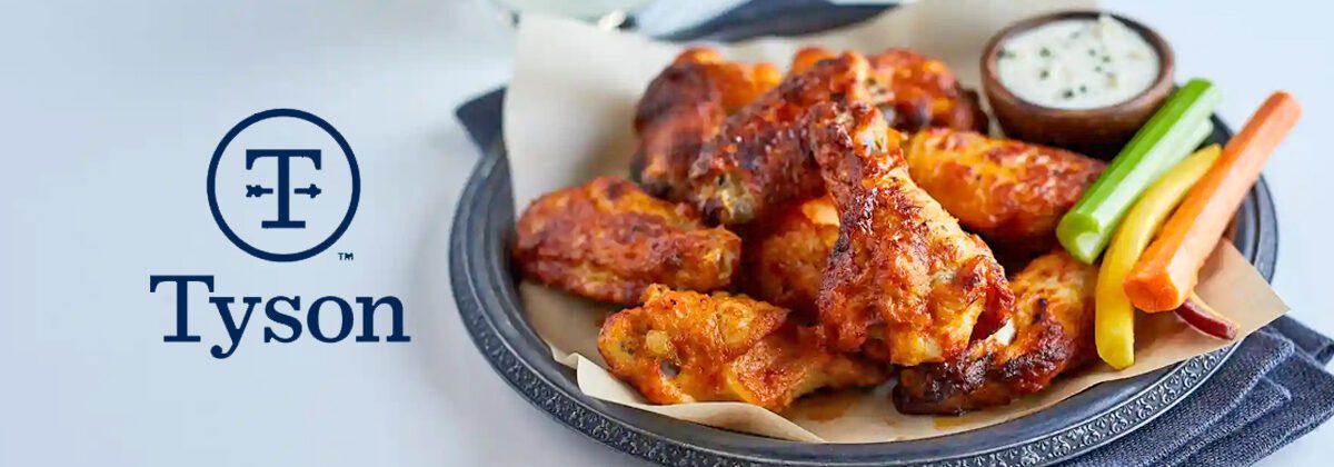 Tyson logo graphic image over white table with black plate of cooked chicken wings with sliced vegetables, dipping sauce.