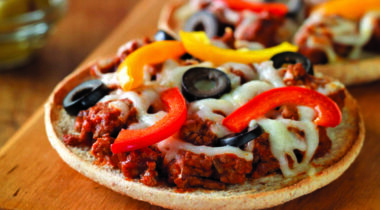 small personal beef pizzas on wood board on wood table