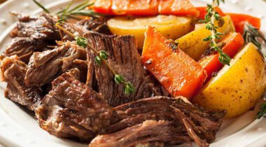 plated pot roast dinner, shows shredded beef with side of root vegetables