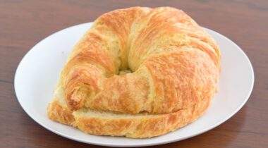 freshly baked croissant cut in half on white plate