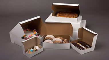 different sized white bakery boxes open showing baked goods