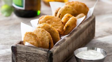 wood appetizer tray with fried pickle chips and dipping cup