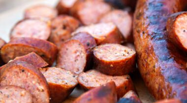 cut up smoked sausage next to link of sausage