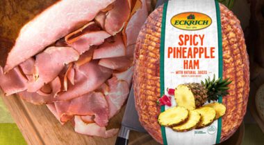 Half sliced ham on cutting board next to packaged spicy pineapple ham