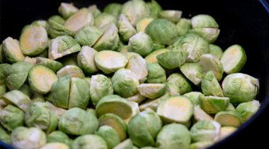 raw fresh Brussel sprouts halved in black pan