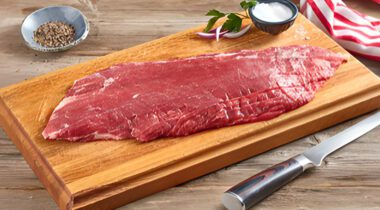 raw beef flank steak on a cutting board