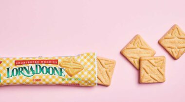 opened package of lorna doone shortbread cookies with four cookies out of package. image over pink background