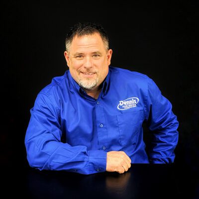 a man smiles at camera with blue shirt on