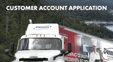 a truck sits ona. paved road in front of trees with mountians in the distance, and a logo on the top of the page