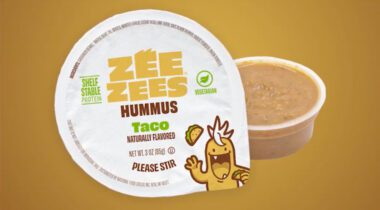 open cup of brown hummus with top label