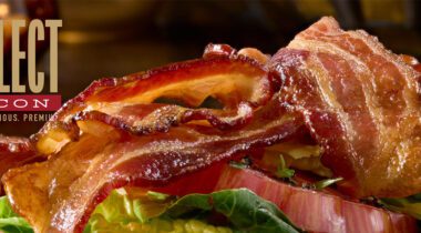 cooked bacon slices on top of lettuce and tomato