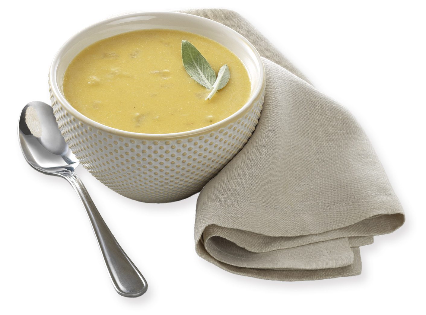 a bowl of squash soup with a spoon and cloth napkin