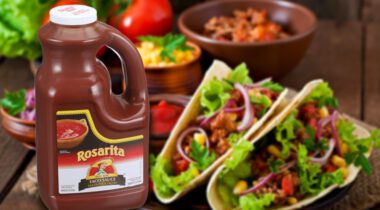 jug of taco sauce over blurred image of two tacos