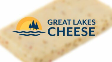 Great Lakes Cheese Logo over blurred cheese block