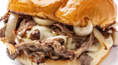 close up of steak and cheese sandwich on greasy bun