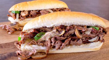 two prepared steak and cheese sub sandwiches