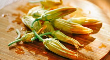 squash blossoms spread out on wood plank