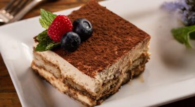tiramisu cake slice on a plate with garnish
